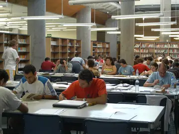Estudiantes en una biblioteca Estudiantes en una biblioteca