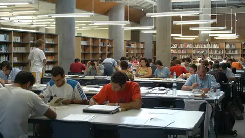 Estudiantes en una biblioteca Estudiantes en una biblioteca