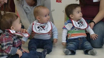 Tres bebés observan a la monitora del curso