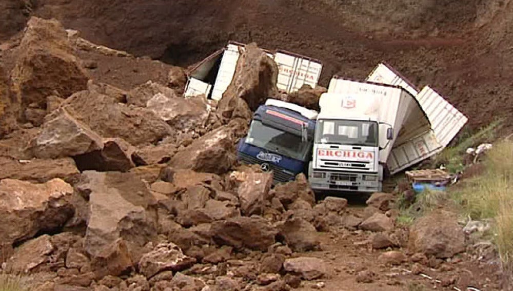 Camiones aplastados por el derrumbe de una montaña