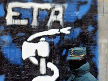 Un guardia civil delante de una pintada de ETA en el Pais Vasco