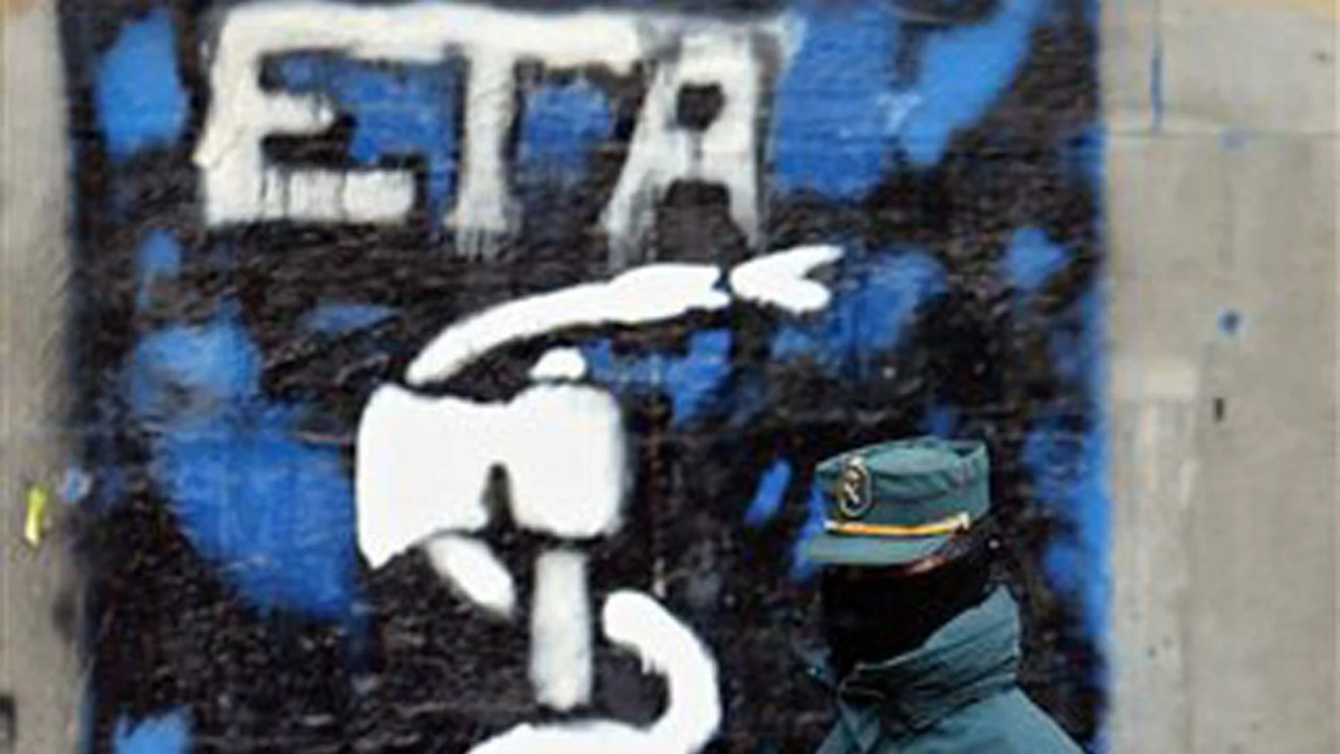 Un guardia civil delante de una pintada de ETA en el Pais Vasco