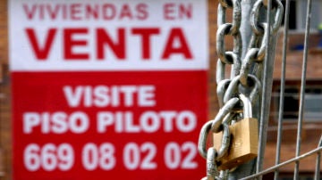 Un cartel anunciador de venta pisos cuelga de una fachada de una nueva promoción en Madrid