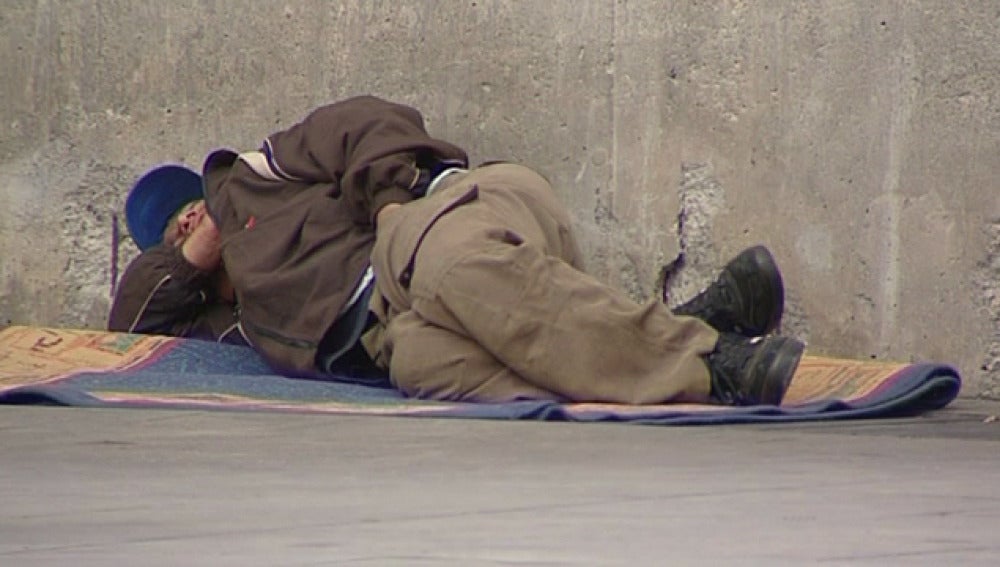 Un mendigo tumbado en la calle