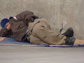 Un mendigo tumbado en la calle Un mendigo tumbado en la calle