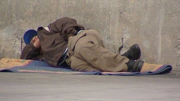 Un mendigo tumbado en la calle