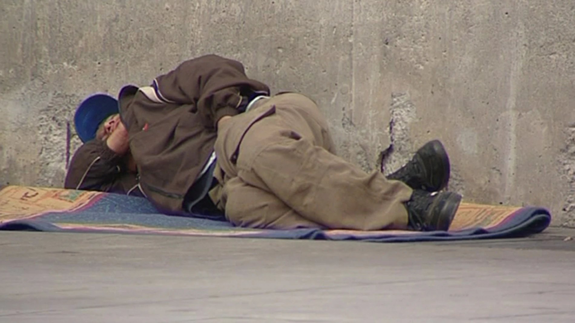 Un mendigo tumbado en la calle Un mendigo tumbado en la calle