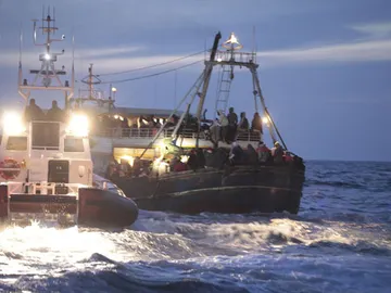 Guardias costeros ayudan a una embarcación recién llegada de Libia en Lampedusa Guardias costeros ayudan a una embarcación recién llegada de Libia en Lampedusa