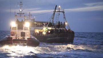 Guardias costeros ayudan a una embarcación recién llegada de Libia en Lampedusa 