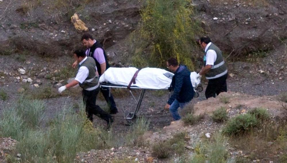 Agentes de la Policía Científica y empleados de los servicios funerarios trasladan el cadáver de Rosa Galera