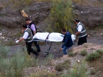 Agentes de la Policía Científica y empleados de los servicios funerarios trasladan el cadáver de Rosa Galera