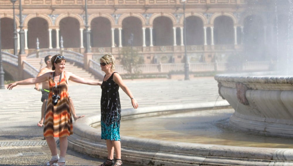 Turistas refrescándose en la Plaza de España