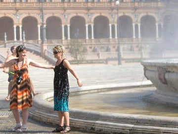 Turistas refrescándose en la Plaza de España