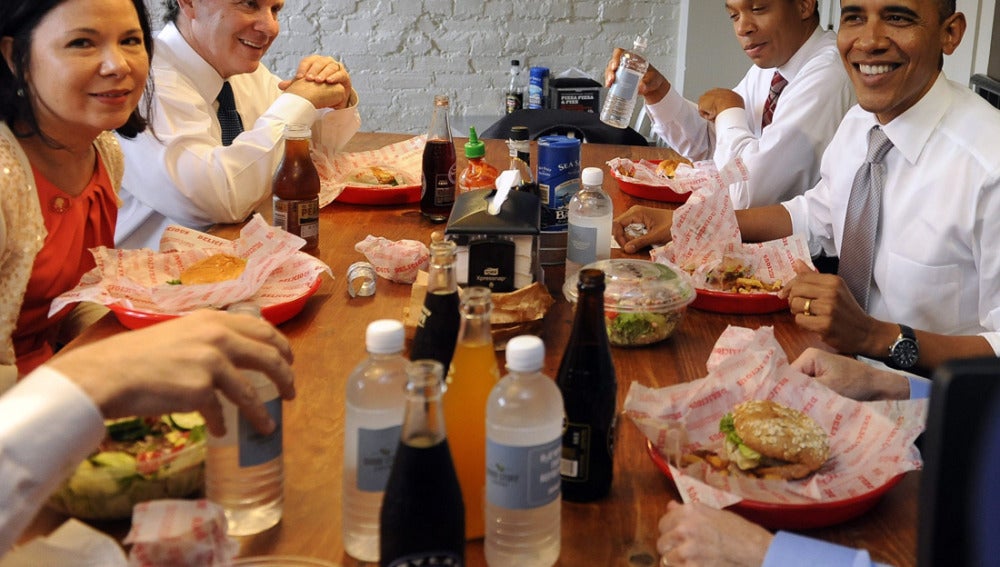 Barack Obama come una hamburguesa junto a su equipo