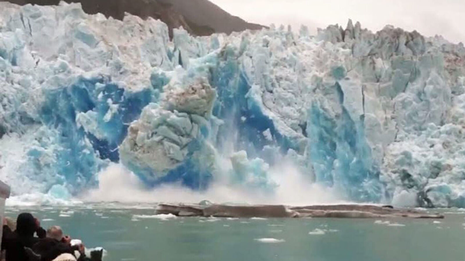Un grupo de turistas observa la caída de la pared de un glaciar demasiado cerca