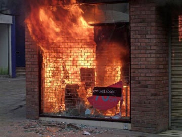 Un almacén de ropa incendiado por los disturbios