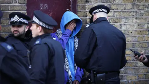 Policía interroga a un protestante Policía interroga a un protestante