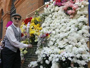 Un chulapo cuelga una flor en la ofrenda a la Virgen de la Paloma Un chulapo cuelga una flor en la ofrenda a la Virgen de la Paloma