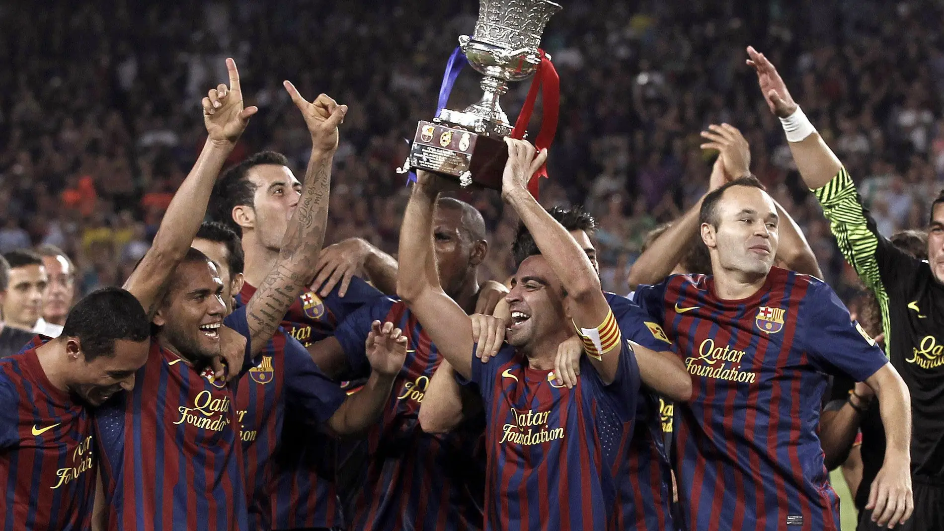 Xavi levanta la Copa ante sus compañeros
