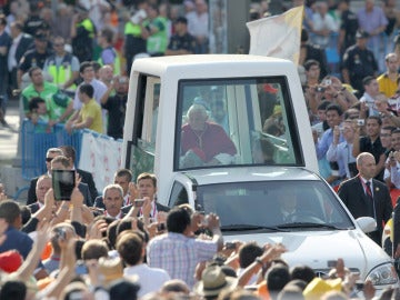 Benedicto XVI en el papamóvil rodeado de gente