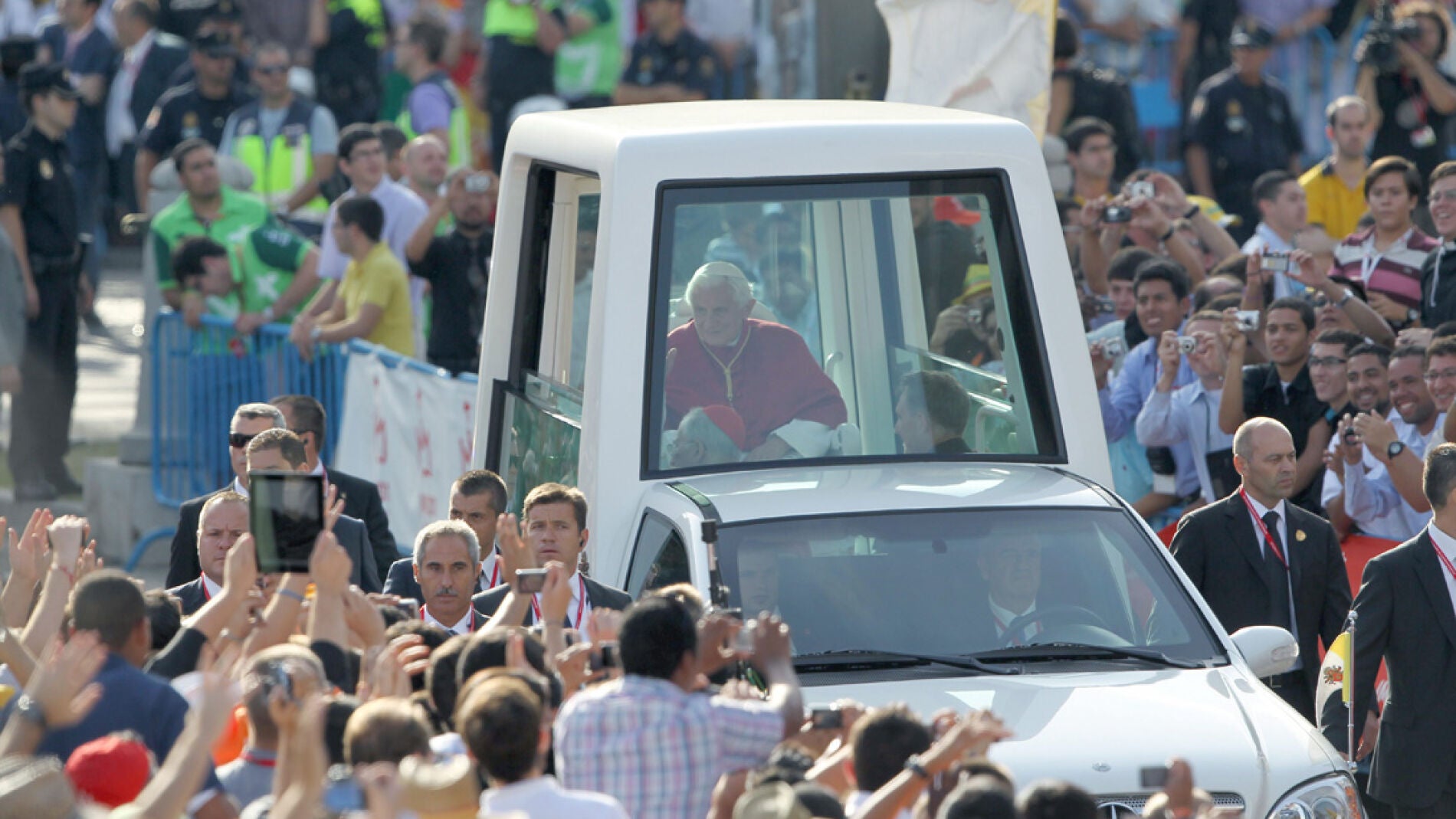 Benedicto XVI en el papam&oacute;vil rodeado de gente