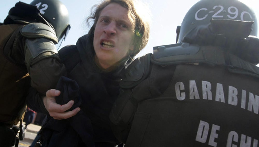 Un joven es detenido por los Carabineros en la marcha de los 38 años por el golpe militar chileno.