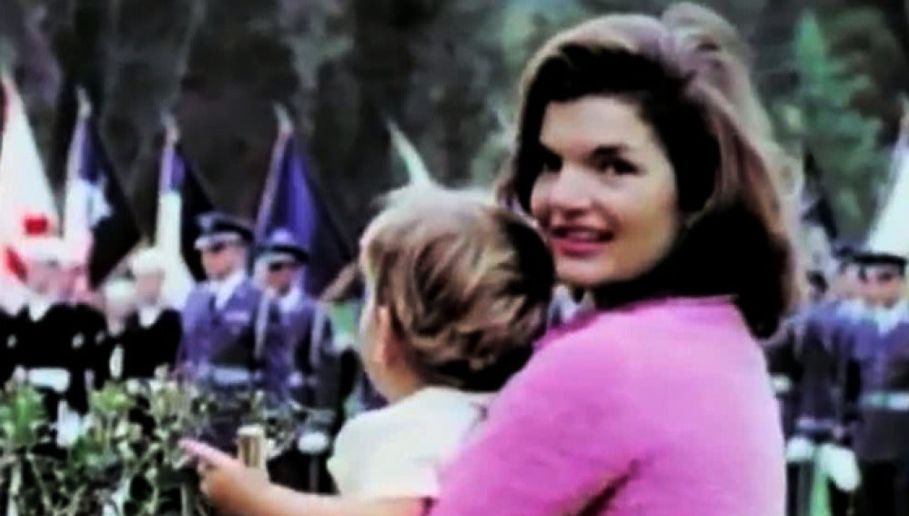 Jackie Kennedy posa con su hijo en brazos en un desfile militar.