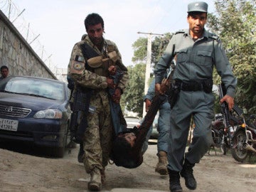 Policías afganos portan el cuerpo de un compañero muerto en Kabul