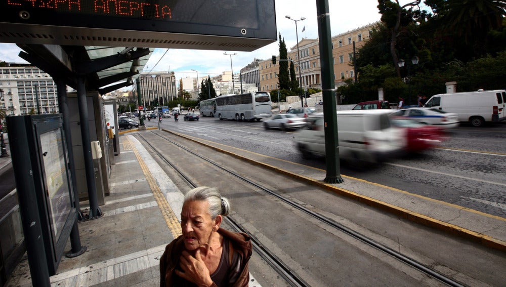 Una mujer en una parada de transportes en Grecia