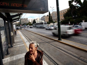 Una mujer en una parada de transportes en Grecia