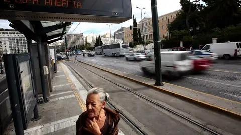 Una mujer en una parada de transportes en Grecia Una mujer en una parada de transportes en Grecia