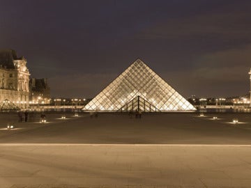 El parisino Museo Louvre iluminado en la noche de la ciudad.