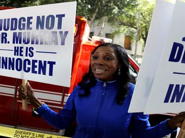 Una mujer sostiene carteles en las que anuncia que el doctor Conrad Murray es inocente. Una mujer sostiene carteles en las que anuncia que el doctor Conrad Murray es inocente.