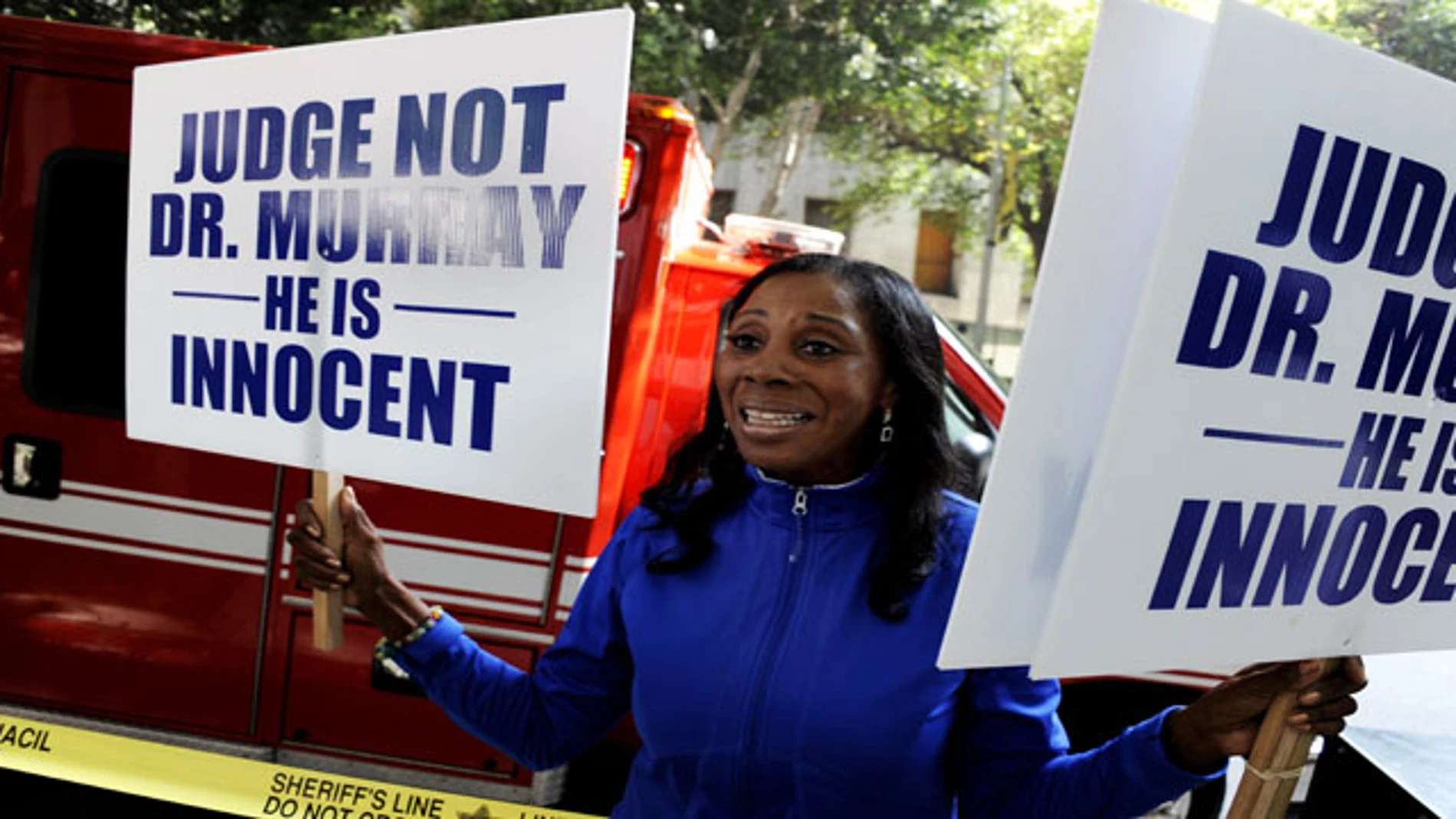 Una mujer sostiene carteles en las que anuncia que el doctor Conrad Murray es inocente. Una mujer sostiene carteles en las que anuncia que el doctor Conrad Murray es inocente.