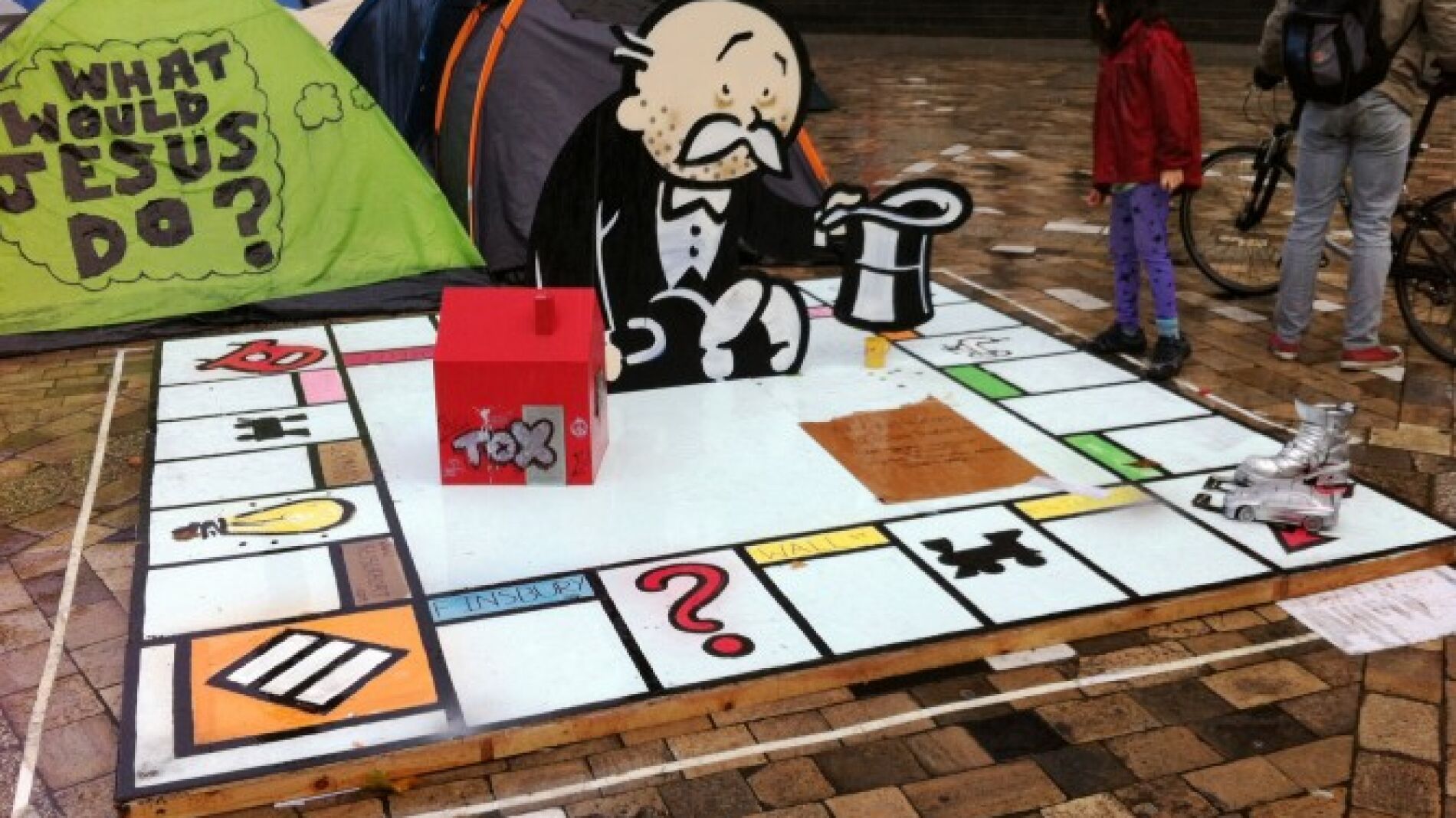 Montaje de Banksy entre las tiendas de campa&ntilde;a de los indignados