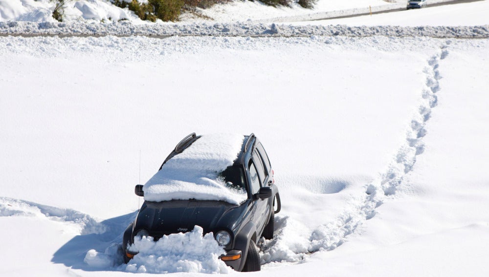 Un coche enterrado por la nieve en  en Bernardston, Massachusetts