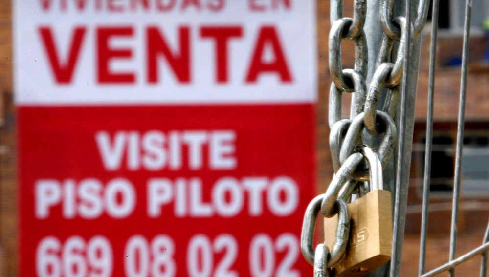 Un cartel anunciador de venta pisos cuelga de una fachada de una nueva promoción en Madrid
