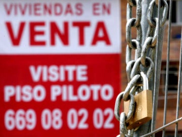 Un cartel anunciador de venta pisos cuelga de una fachada de una nueva promoción en Madrid