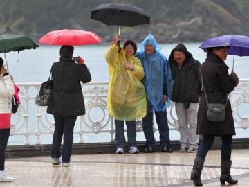 Un grupo de turistas se fotografía frente al mar, en el Paseo de la Concha de San Sebastián