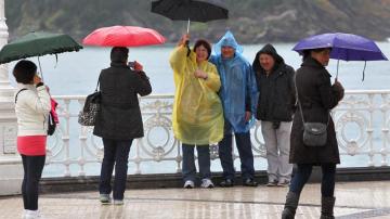 Un grupo de turistas se fotografía frente al mar, en el Paseo de la Concha de San Sebastián