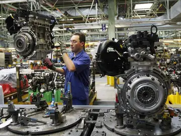 Un hombre trabaja en una cadena de montaje Un hombre trabaja en una cadena de montaje