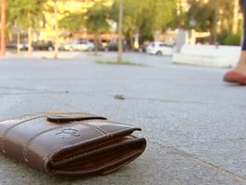 Una cartera perdida en el suelo de un parque