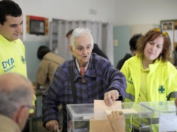 Anciana vota acompañada de sanitarios
