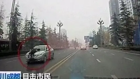 Un policía chino sobre el capó de un taxi ilegal Un policía chino sobre el capó de un taxi ilegal