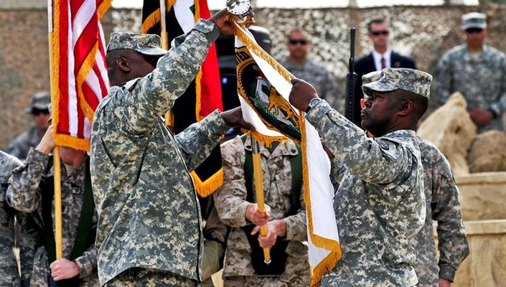 El general Lloyd James Austin III y al comandante Joseph R. Allen, recogiendo la bandera