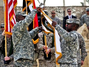 El general Lloyd James Austin III y al comandante Joseph R. Allen, recogiendo la bandera
