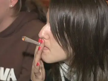 Una joven fuma droga en un coffee shop holandés Una joven fuma droga en un coffee shop holandés