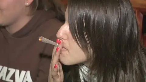 Una joven fuma droga en un coffee shop holandés Una joven fuma droga en un coffee shop holandés