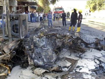 Policías iraquíes inspeccionan los daños causados tras un atentado en Irak.