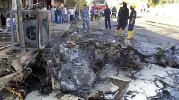 Policías iraquíes inspeccionan los daños causados tras un atentado en Irak.